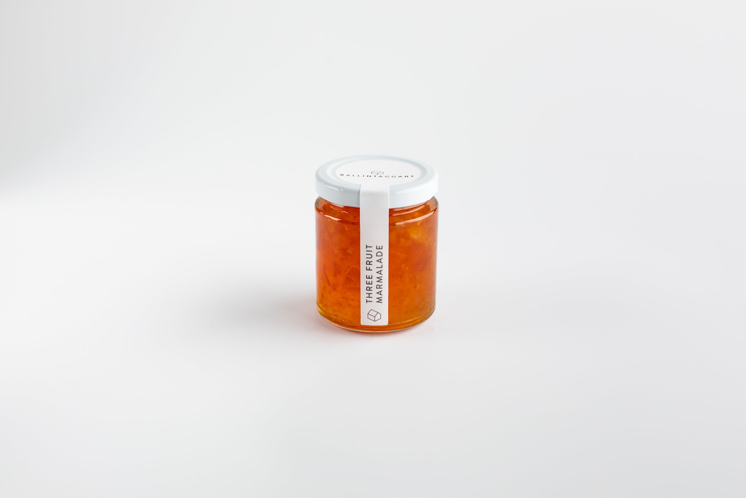 Jar of marmalade with a white lid on a light gray background