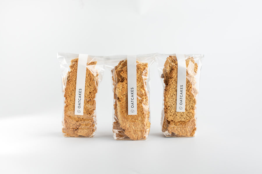 Three packages of oatcakes on a white background