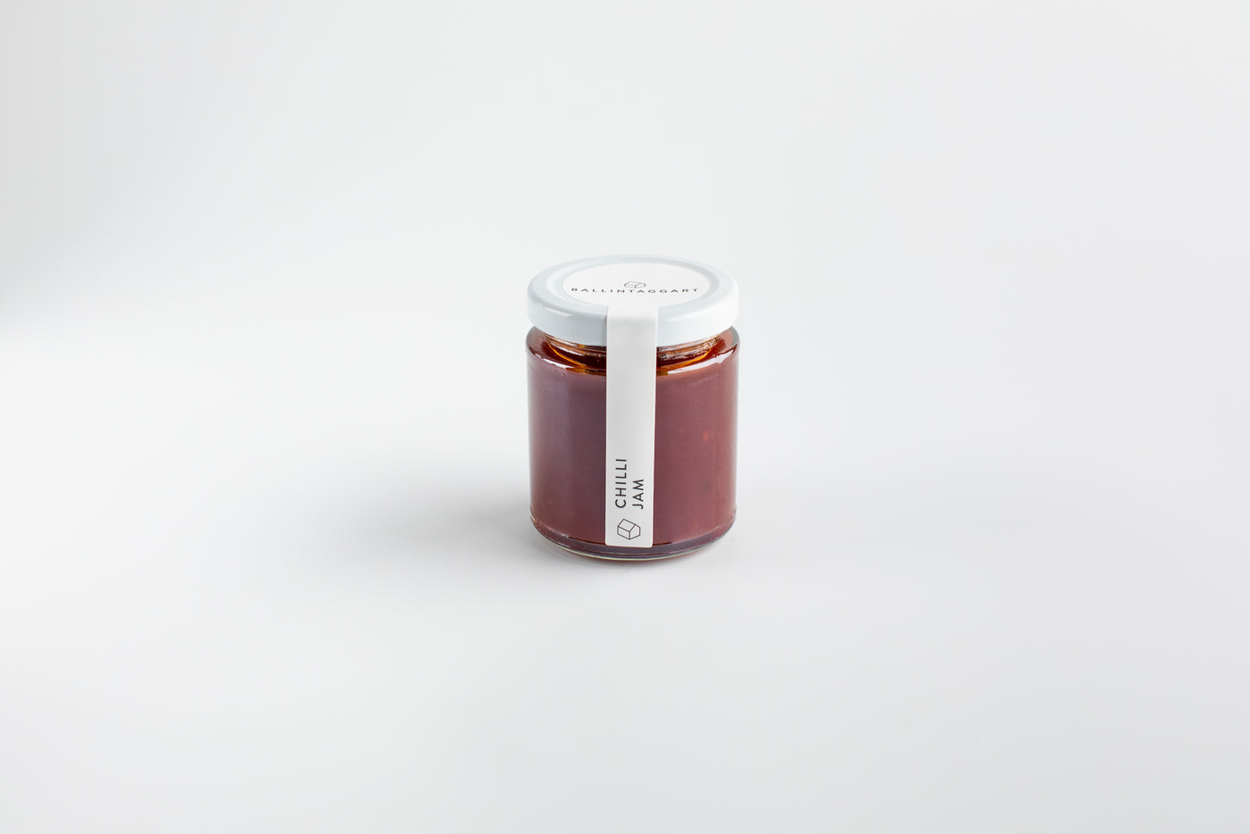 Jar of chili jam on a white background