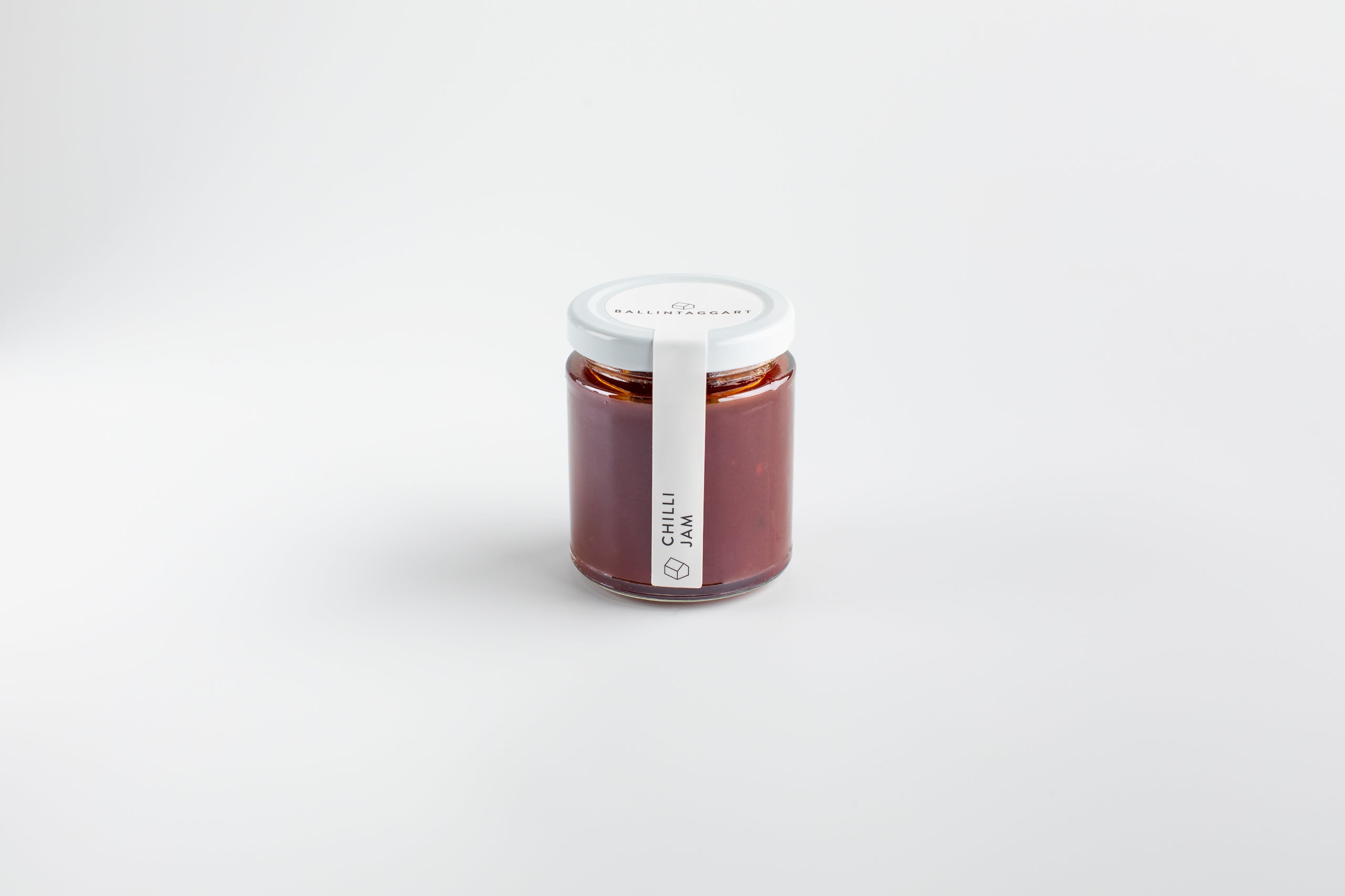 Jar of chili jam on a white background