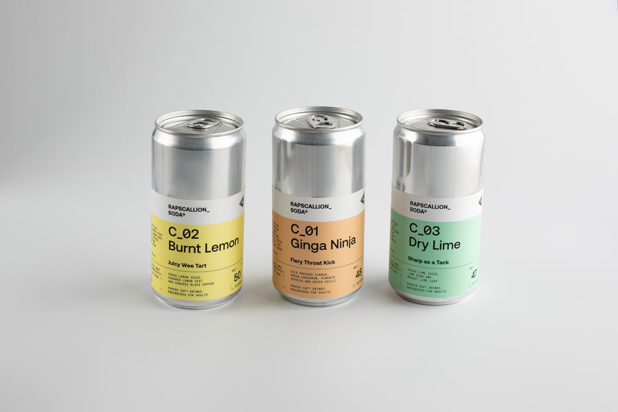 Three cans of a beverage brand on a light gray background