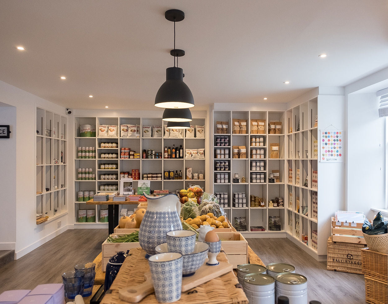 Modern kitchen with shelves, table, and various items
