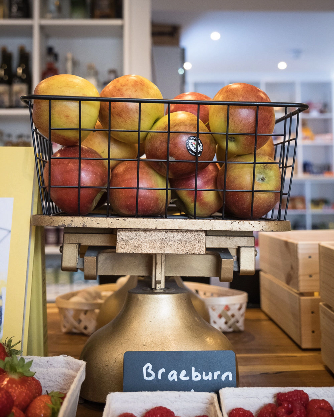 Basket of Braeburn apples on a wooden stand with a blurred background