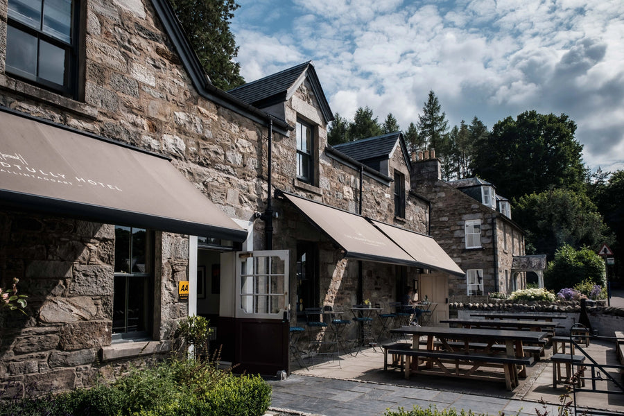 Stone building with outdoor seating area under a clear blue sky