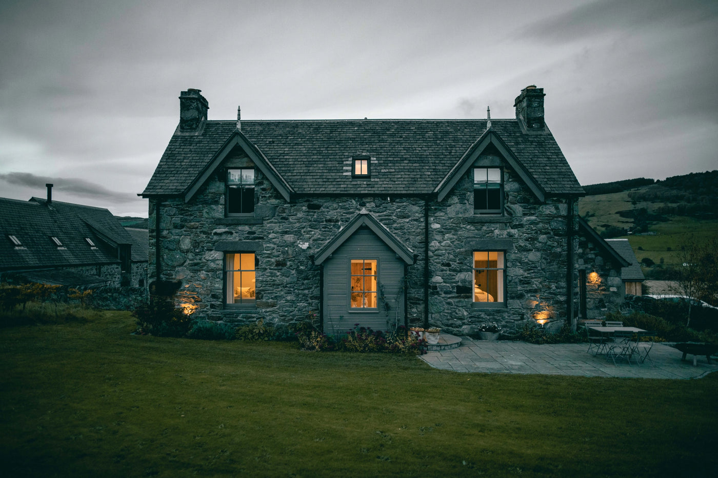 Stone house with glowing windows on a cloudy day